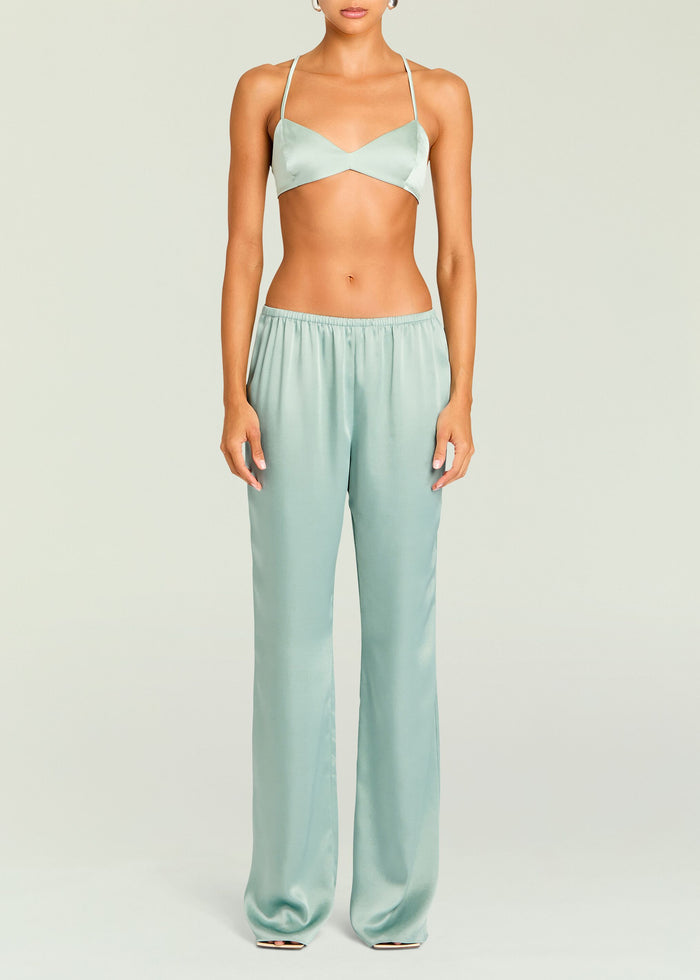 Front view of a pastel green satin Courtney Bralette with thin straps and a twisted center, paired with matching satin pants.