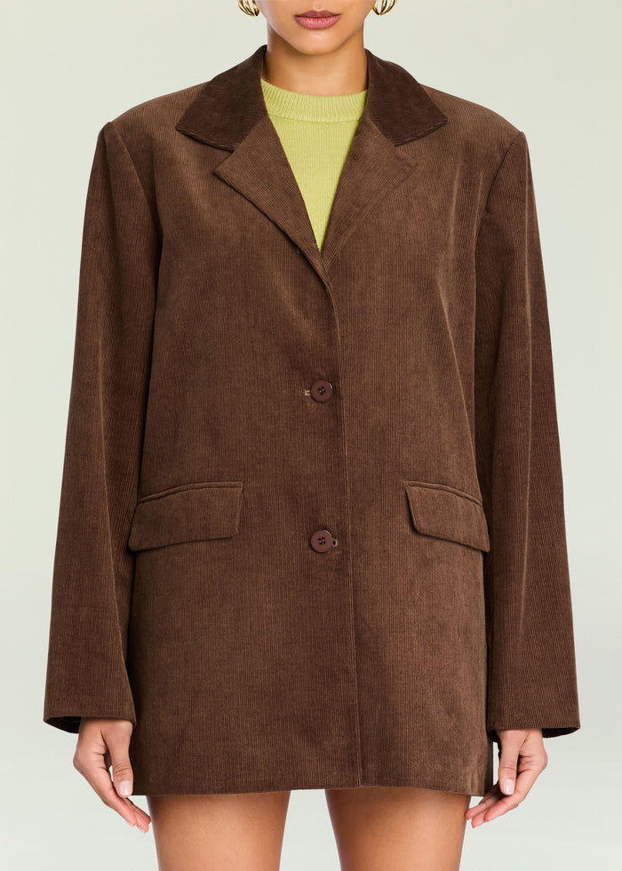 Brown corduroy Hera blazer worn over a lime knit top with wide lapels and front flap pockets