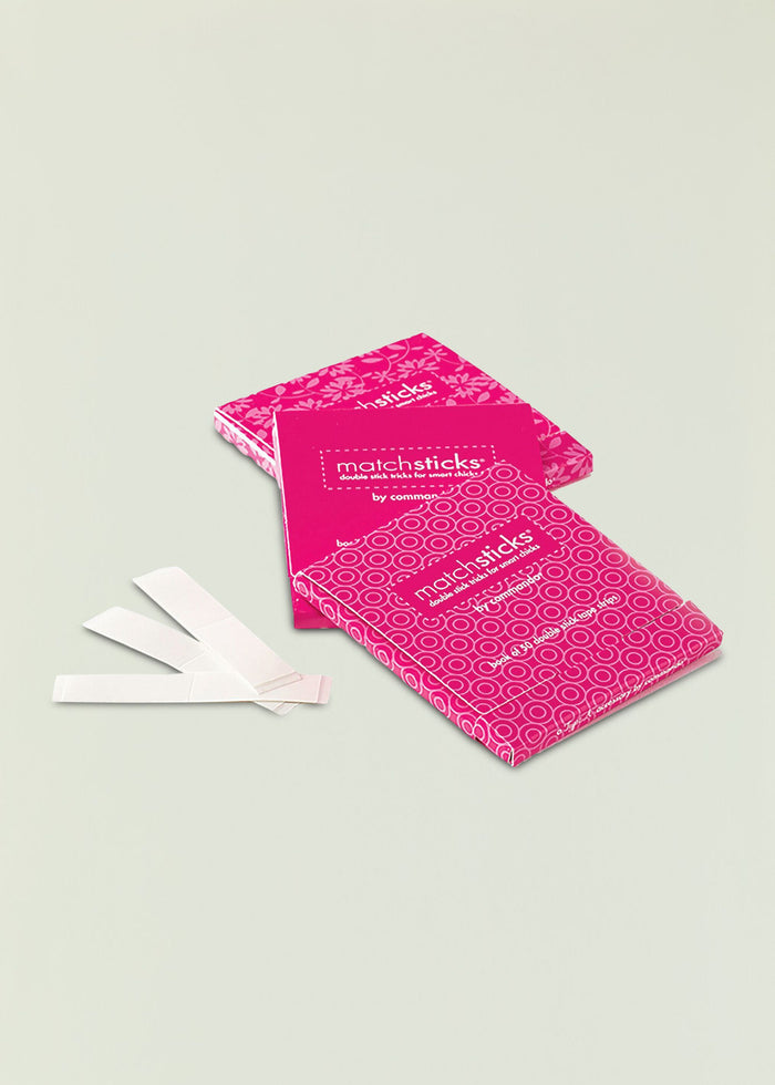 Bright pink matchsticks packaging with a floral pattern on a pale background