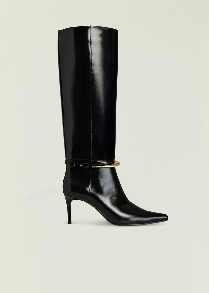 Sancia Boot tall glossy black knee-high boot with thin gold buckle strap at the ankle