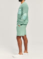 Side view of a man in the mint green Devin Sweater featuring elbow patches and knit texture thumbnail image 3 of 4